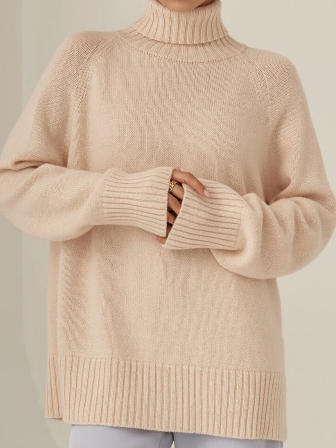 Blush pink cashmere turtleneck sweater with raglan sleeves and ribbed cuffs and hem.