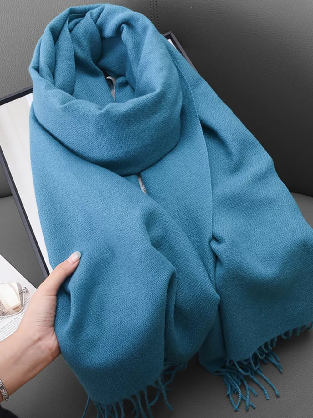 Light blue scarf with fringe detail and textured weave, styled for versatile wear.