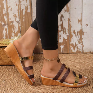Glistening dual-strap wedge sandals in brown and gold with a cork wedge heel.