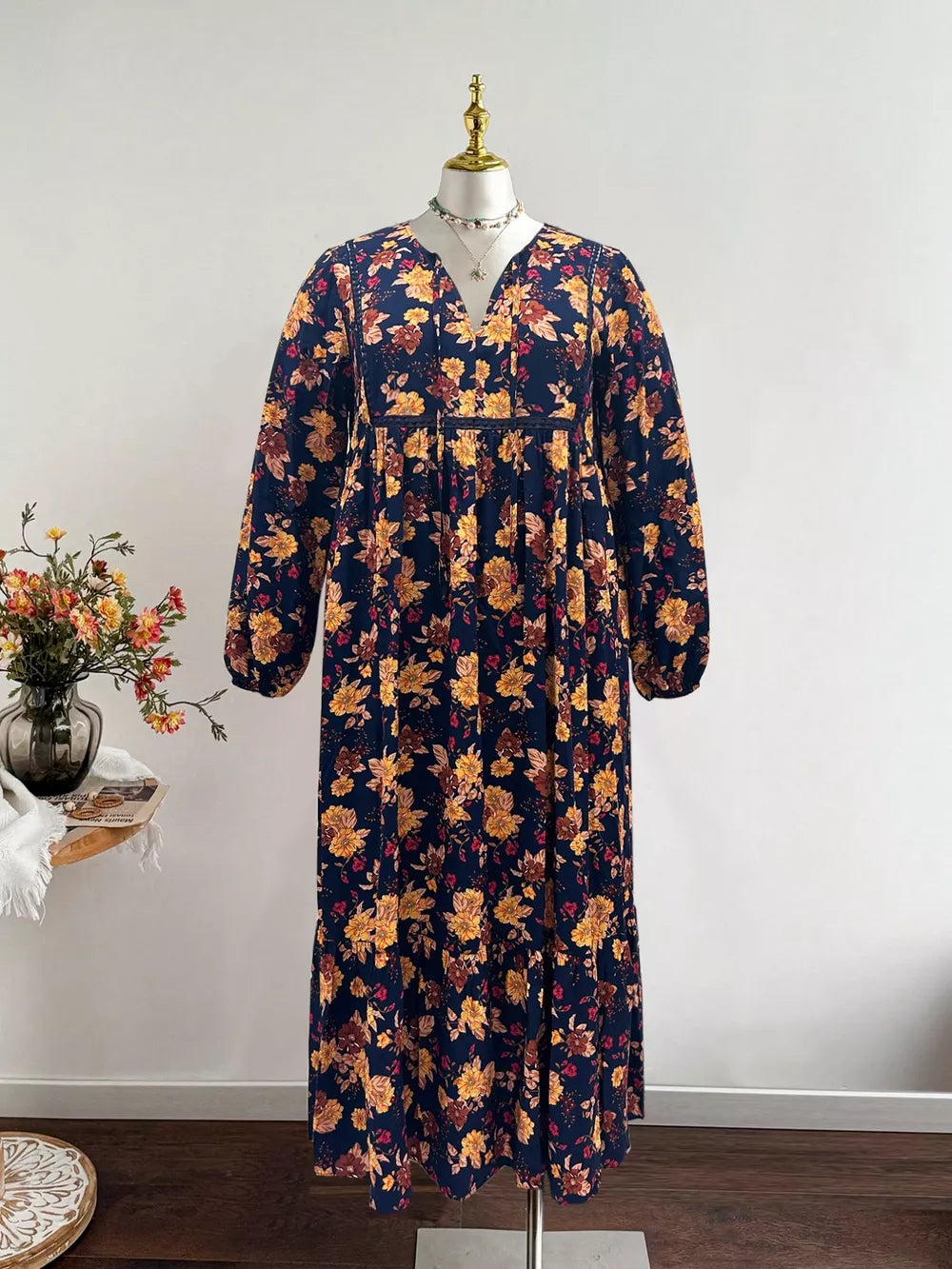 Maxi dress with V-neck, balloon sleeves, and floral print on navy blue fabric.