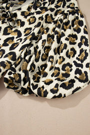 Leopard print tie-neck peplum blouse with gathered sleeves and cinched cuffs.