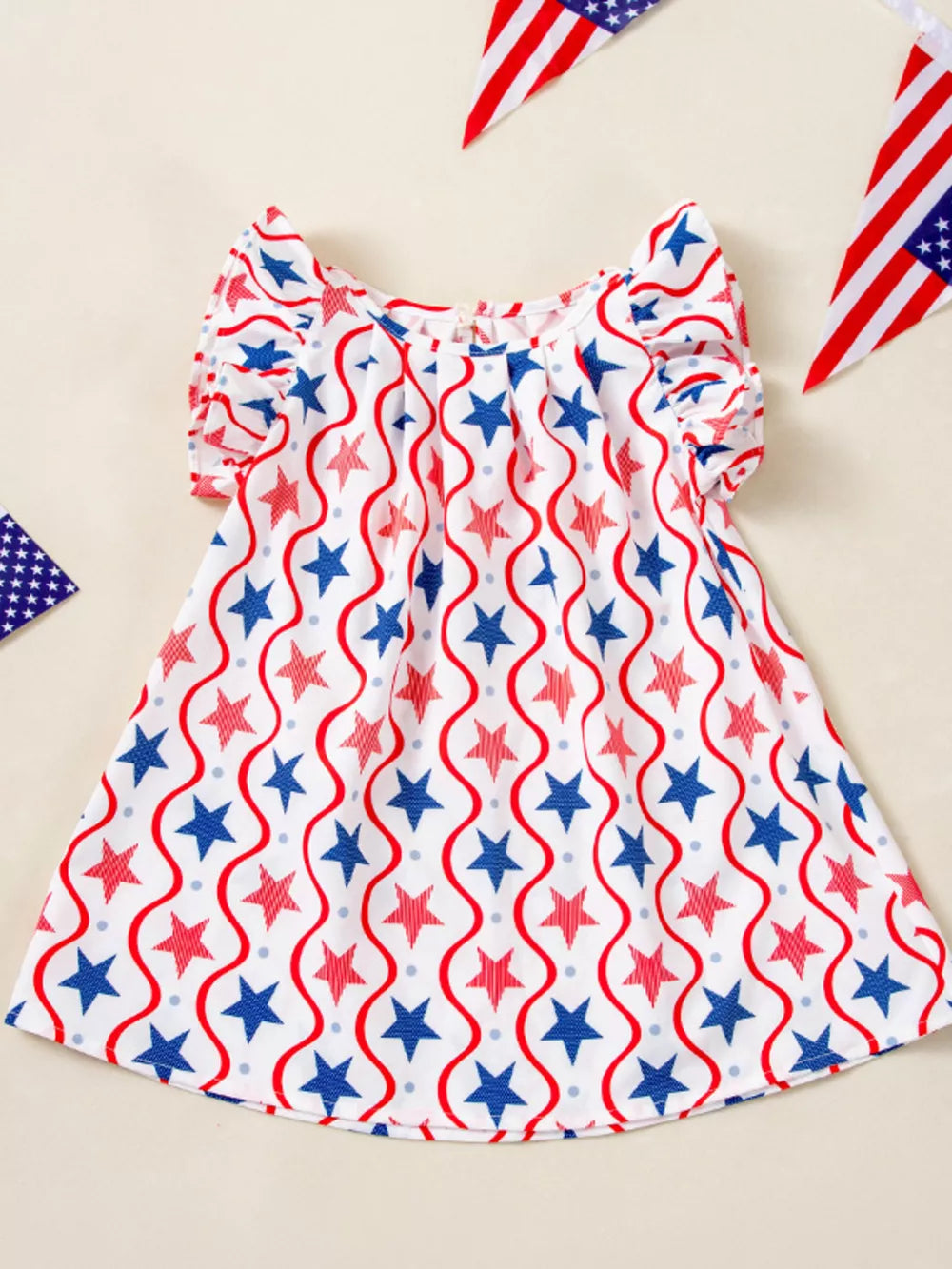 Toddler dress with red and blue stars and wavy lines pattern, ruffle sleeves.