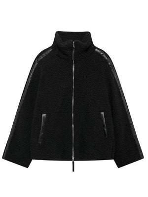 Black teddy fleece zip-up jacket with contrast piping and faux leather trim.