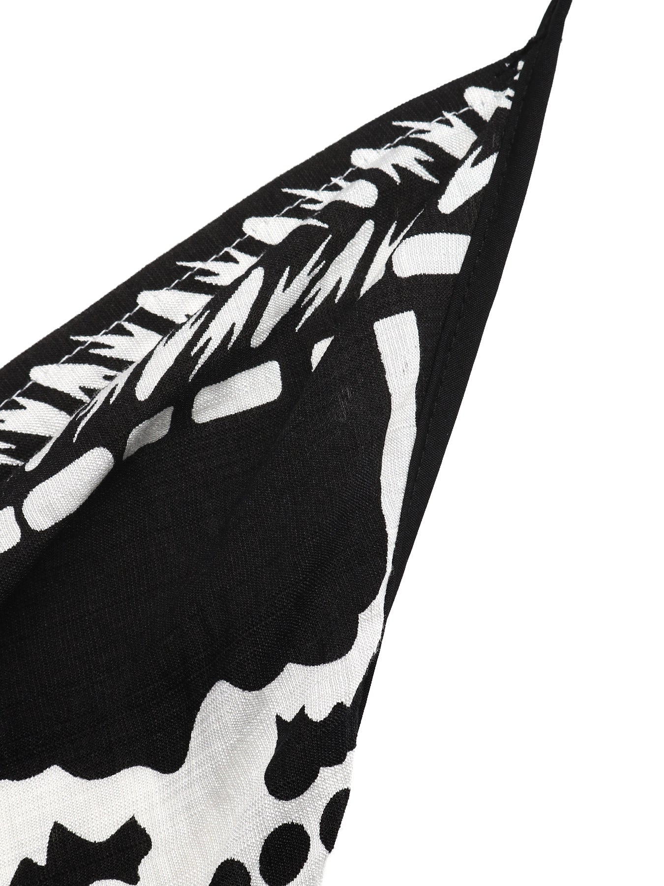 Black and white floral print halter neck maxi dress detail with asymmetrical hem.