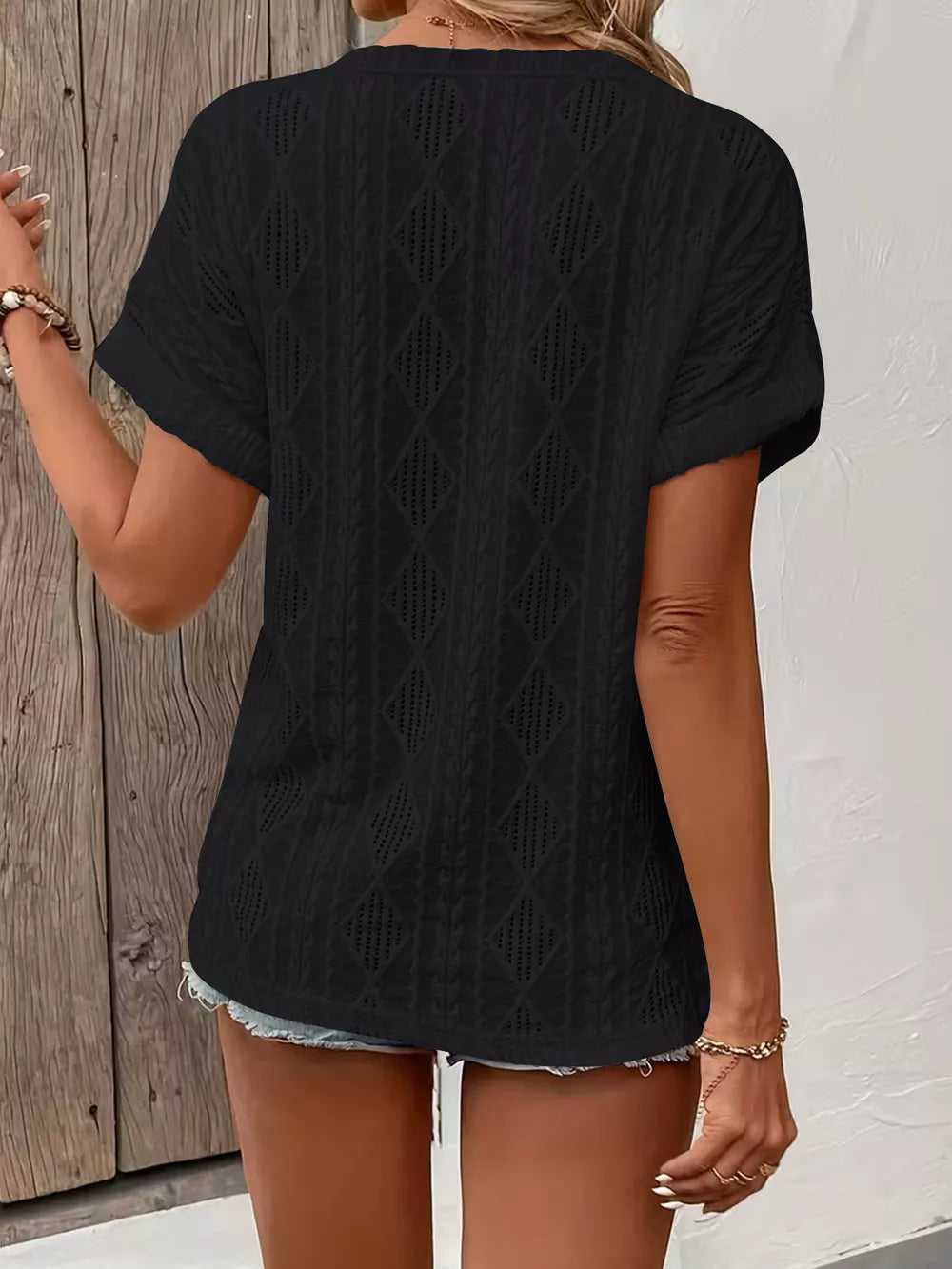 Black diamond pattern short-sleeve t-shirt with textured knit and open weave details.