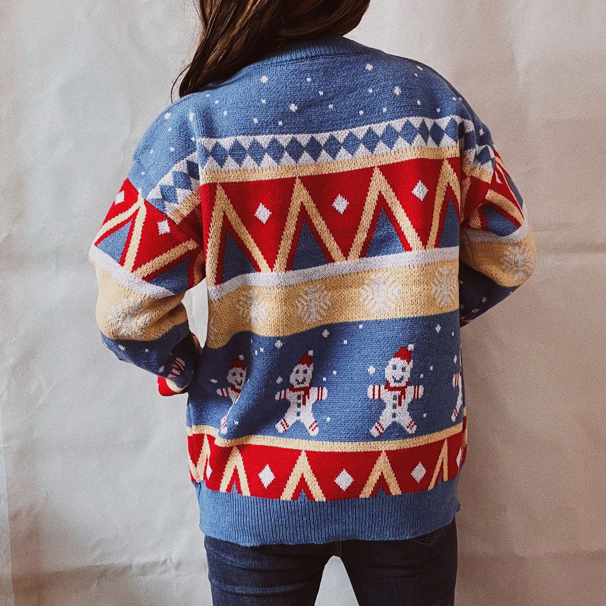Festive Fair Isle knit jumper in blue with gingerbread men and geometric pattern.