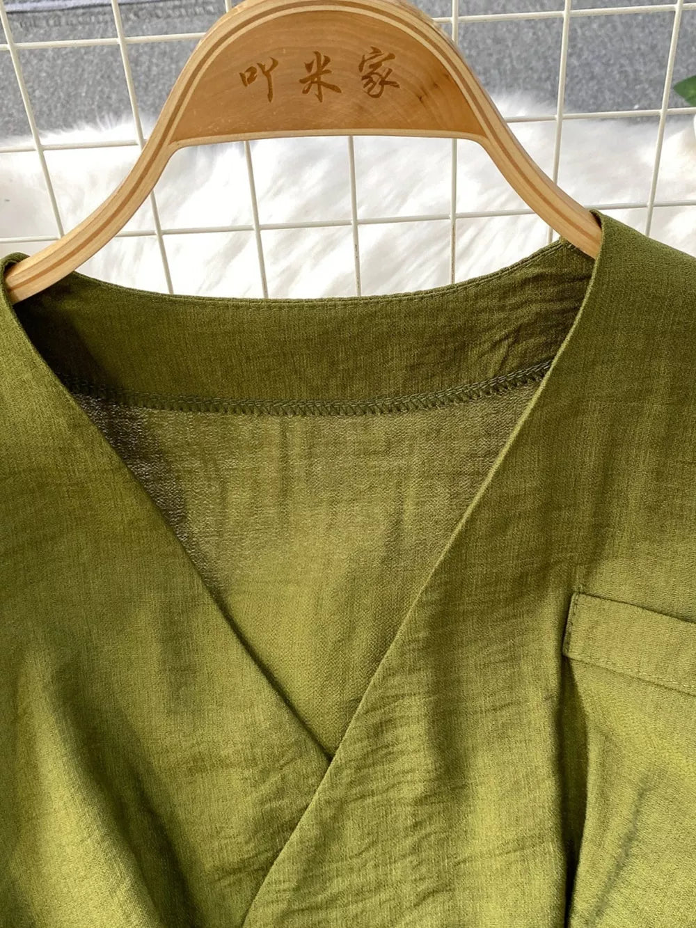 Green V-neck wide leg jumpsuit with a pocket detail.