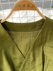 Green V-neck wide leg jumpsuit with a pocket detail.