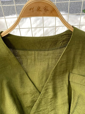 Green V-neck wide leg jumpsuit with a pocket detail.