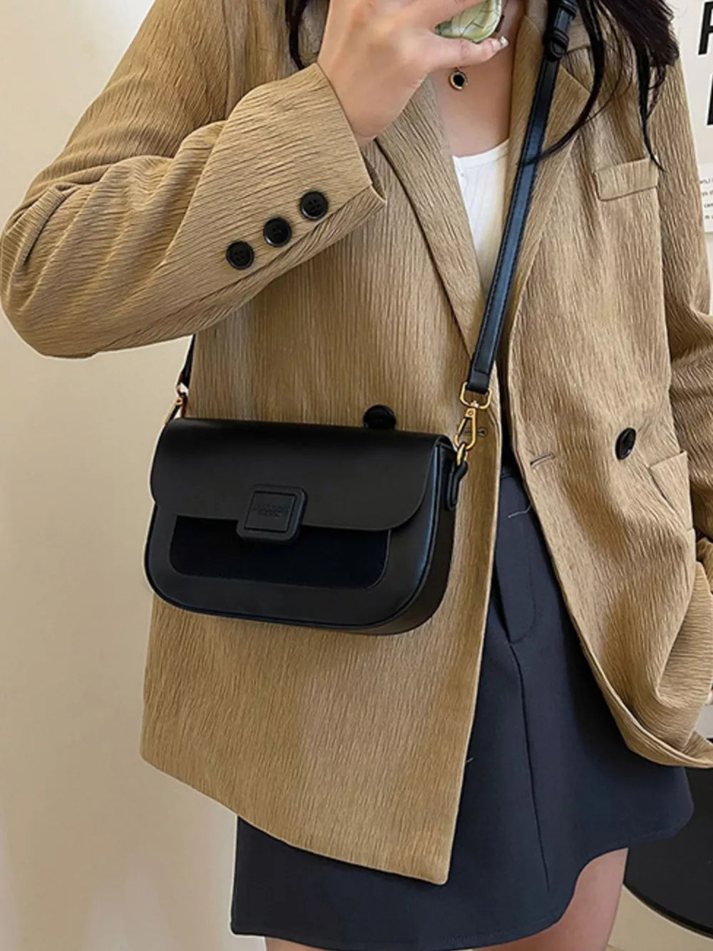 Chic two-tone crossbody bag in black with a suede panel and gold hardware.