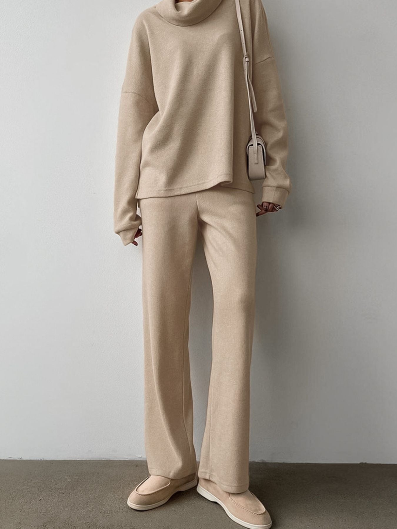 Beige cowl-neck turtleneck and wide-leg pants set with a relaxed fit.