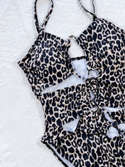 Leopard print one-piece swimsuit with cutout details and lace-up front.