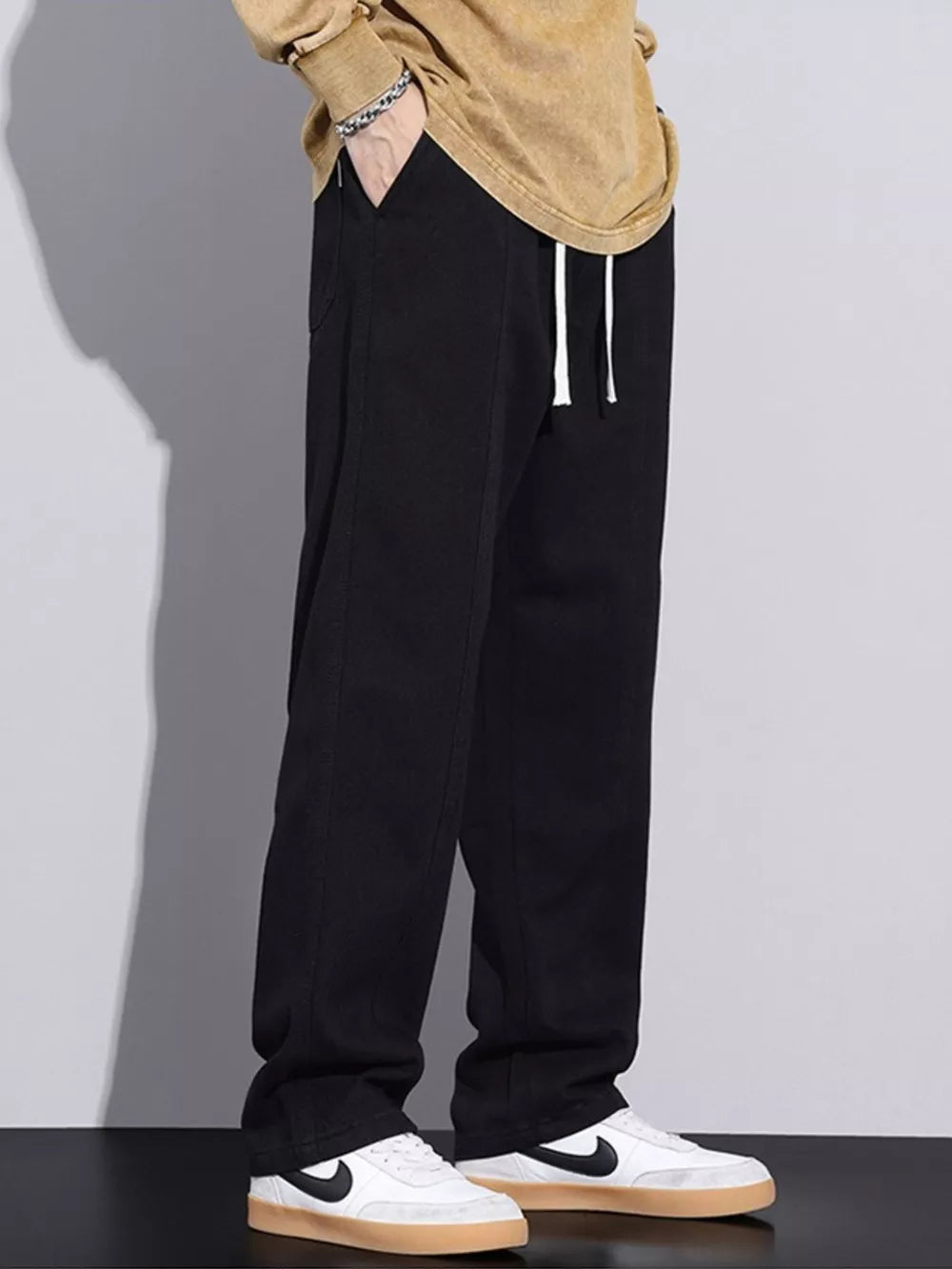 Black cotton relaxed fit jeans with drawstring waist and white drawstrings.