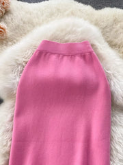 Pink knit midi skirt with ribbed waistband and side split detail.