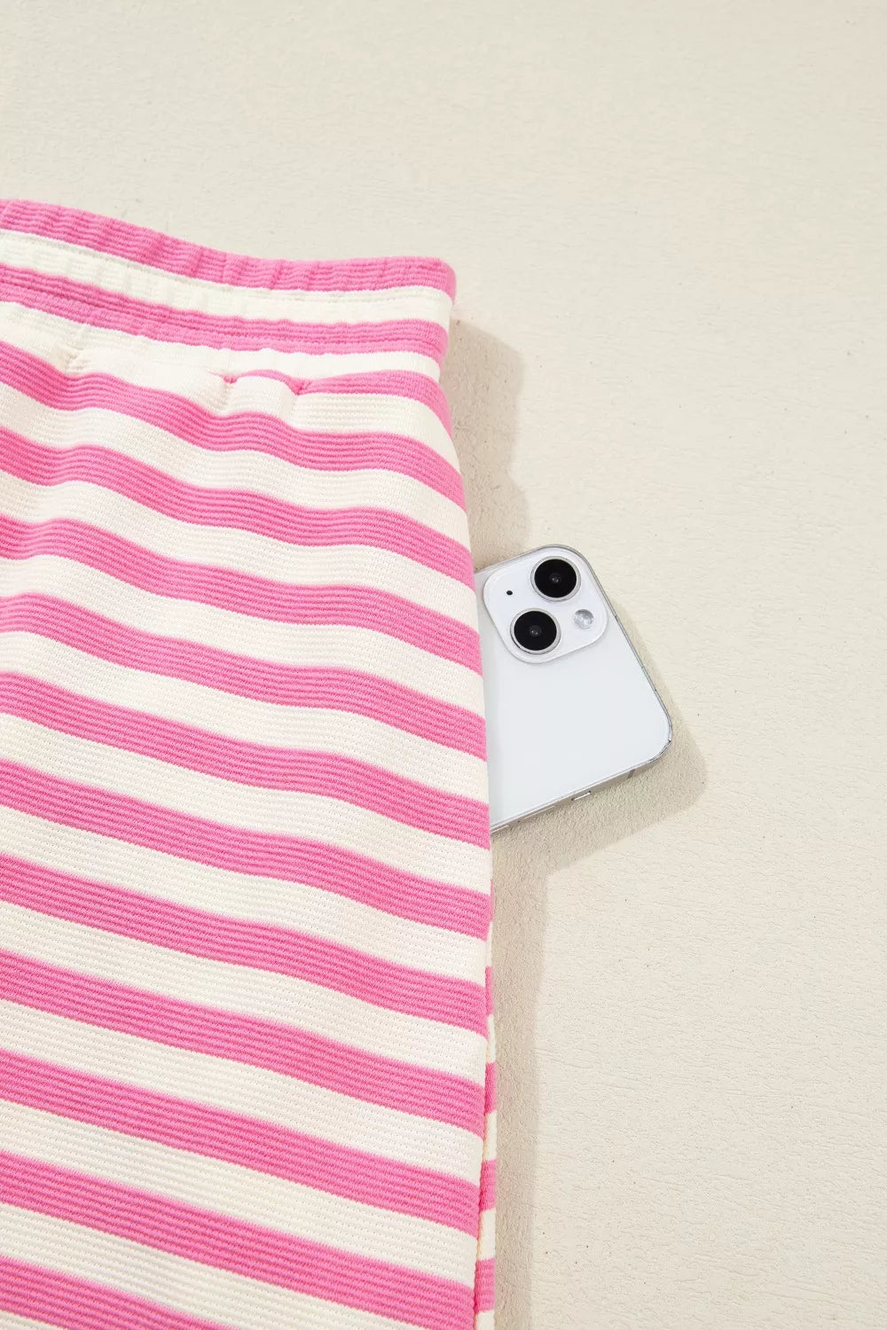 Pink and white striped cotton bikini bottoms with a phone in the pocket.