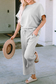 Light gray textured knit tee and wide leg pants set with drawstring waist and pockets.