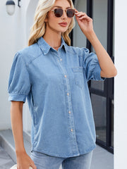 Medium wash denim button-down blouse with puffed short sleeves and a collared neckline.