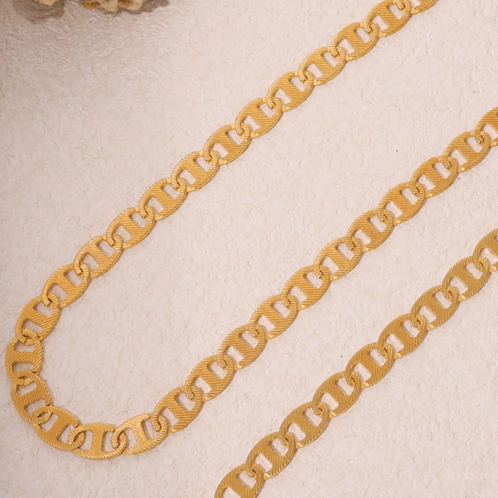 Gold anchor link chain necklace with textured oval links