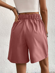 Pleated front bermuda shorts in dusty pink with elastic waist and side pockets.
