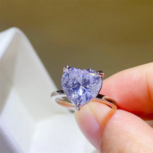 Silver ring with a large, clear heart-cut moissanite solitaire stone.