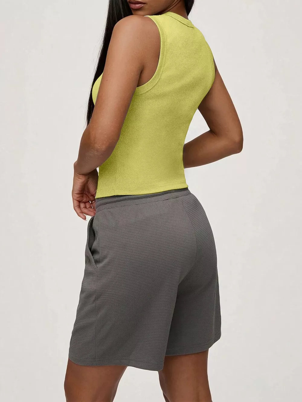 Yellow ribbed button-front fitted tank top with a mock neck, shown from the side.