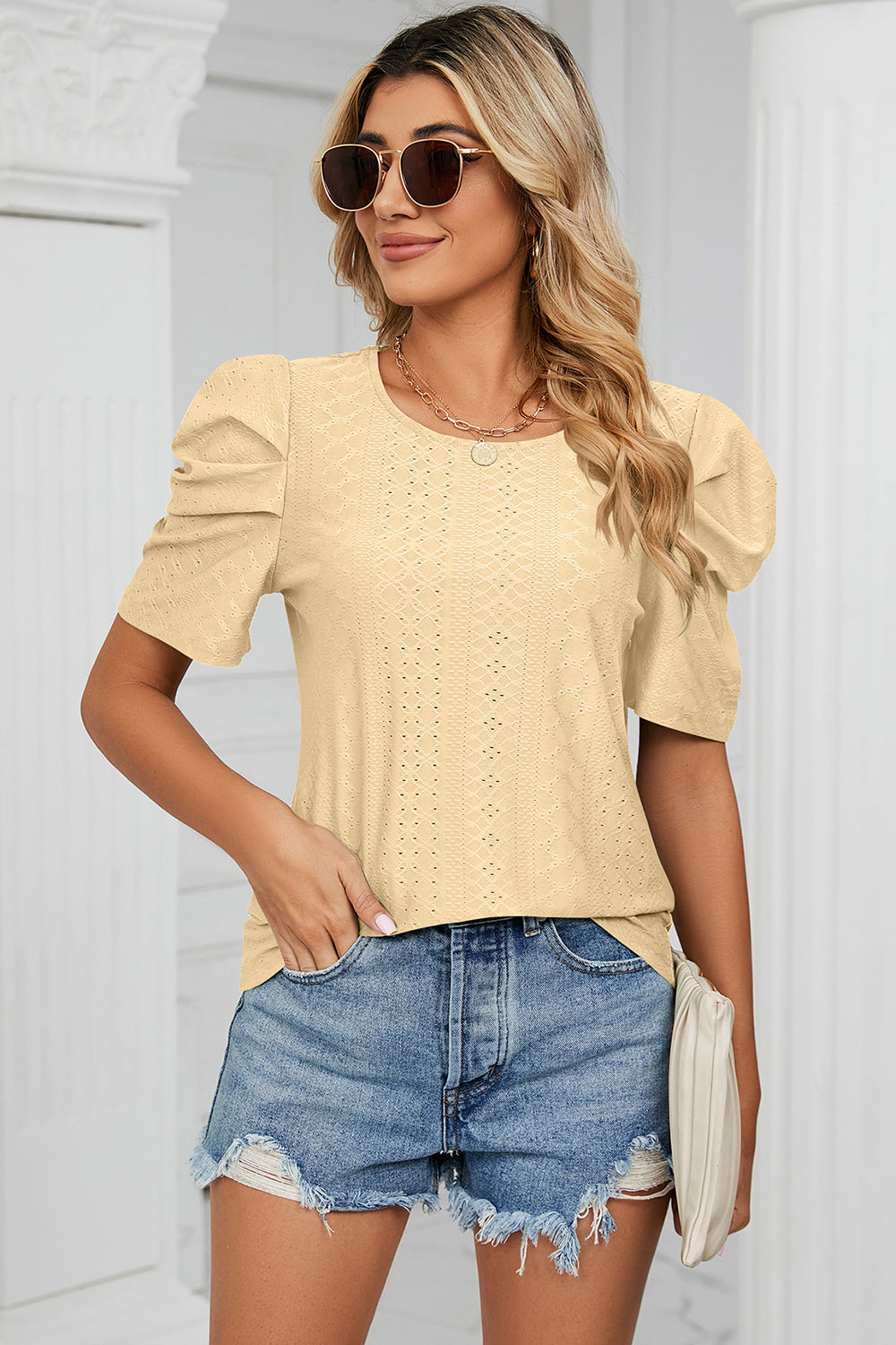 Perforated puff sleeve top in light yellow with a textured pattern and round neckline.