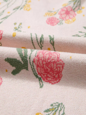Floral v-neck knit sweater with pink and yellow flowers on a cream background.