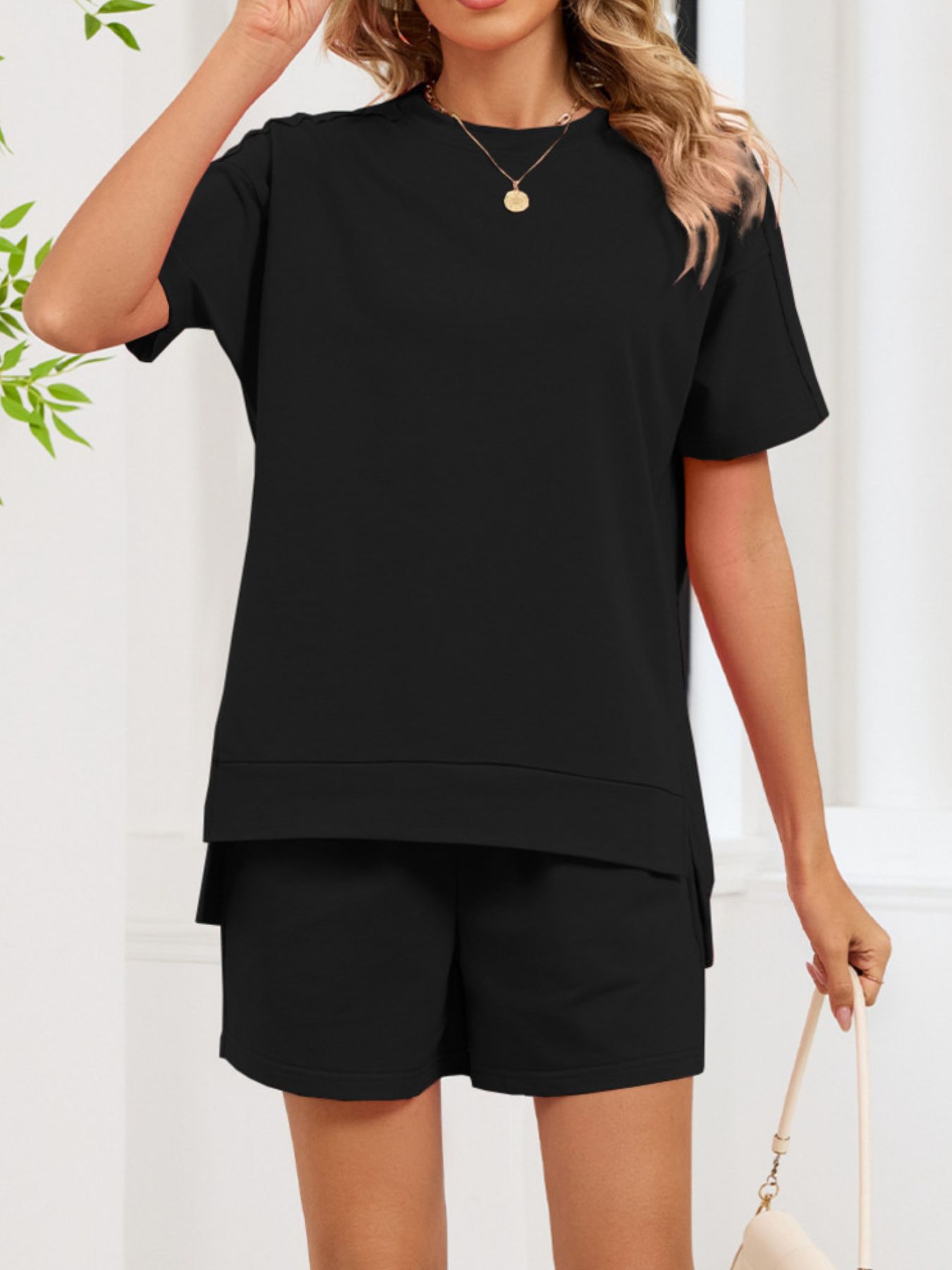 Black relaxed two-piece set with short sleeves, crew neck, and shorts with pockets.