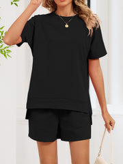 Black relaxed two-piece set with short sleeves, crew neck, and shorts with pockets.