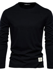 Black crew-neck long-sleeve tee with a textured patch detail on the hem.
