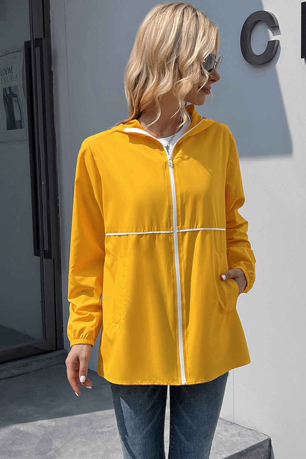 Yellow hooded rain coat with white zipper and trim, full zip, pockets
