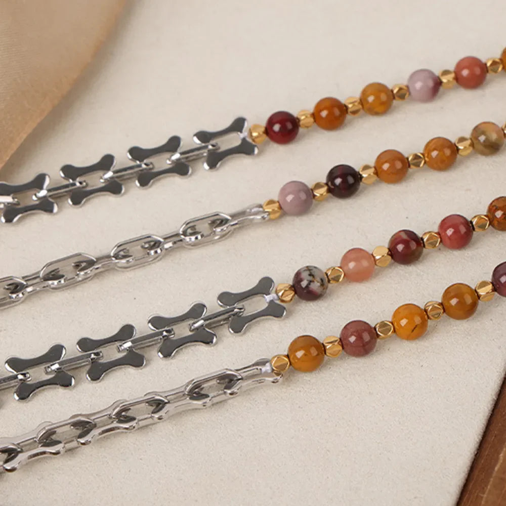Silver chain necklace with bone links and beaded strands in earthy tones.