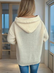 Beige cable knit hoodie with toggle detail and ribbed trim.