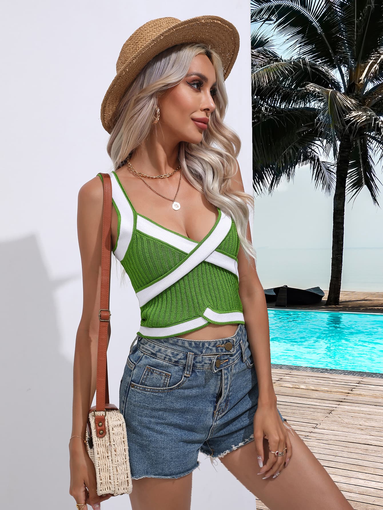 Green knit crossover tank top with white contrast trim and crisscross straps.