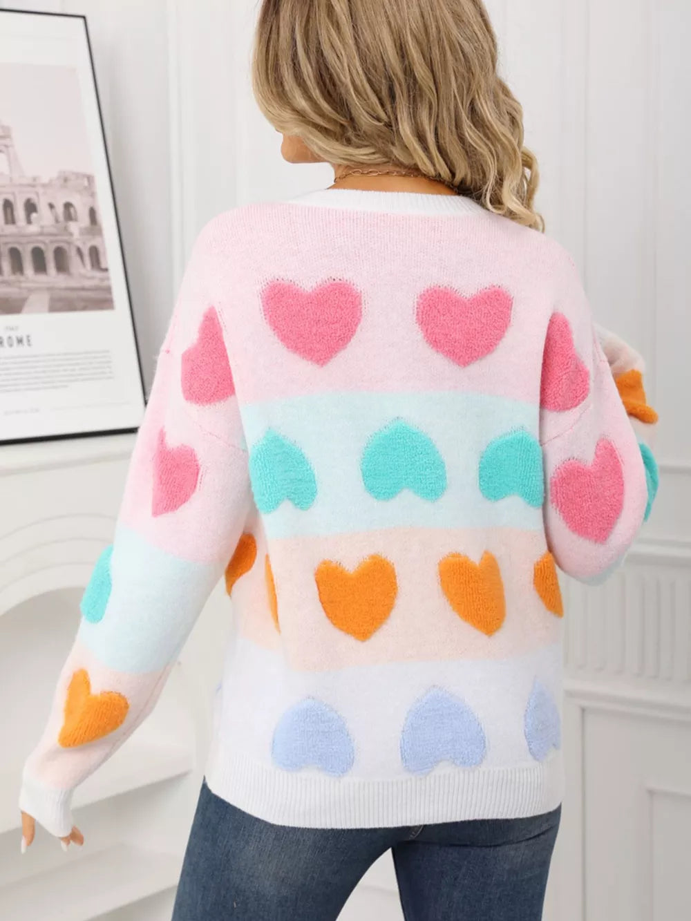 Fuzzy knit sweater with multicolor heart pattern and stripes.