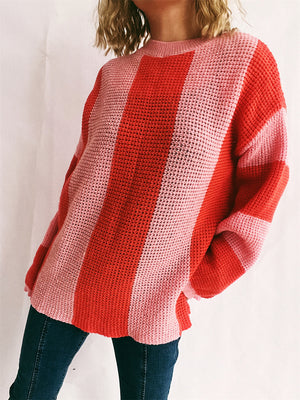 Vertical stripe waffle knit sweater in pink and orange-red with a crew neck.