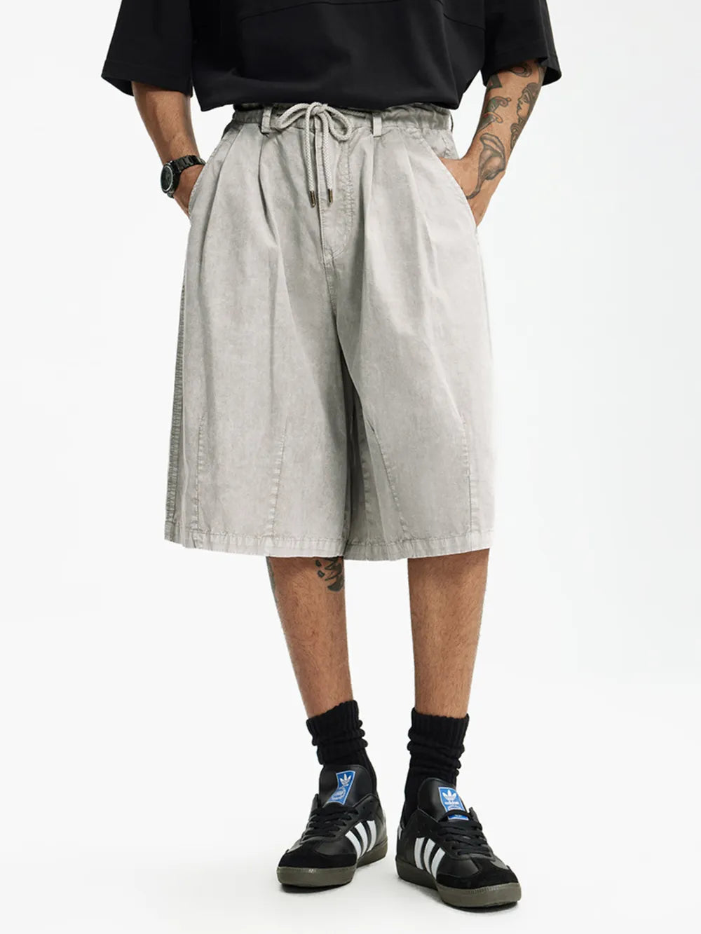 Light gray cotton wide-leg chino shorts for men with drawstring waist and pleats.