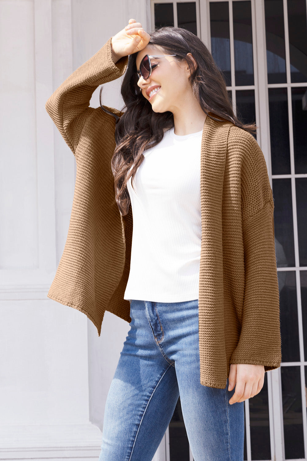 Camel waffle knit cardigan with open front and long sleeves, styled with a white top and jeans.