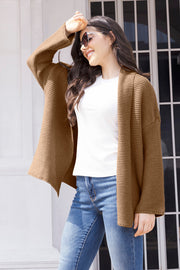 Camel waffle knit cardigan with open front and long sleeves, styled with a white top and jeans.