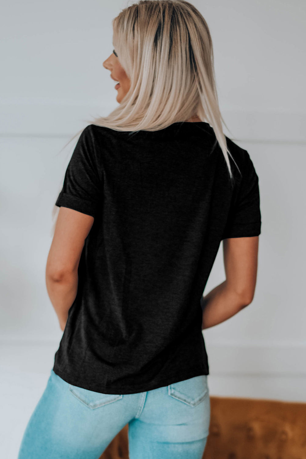 Black t-shirt with rolled sleeves and a graphic detail on the back.