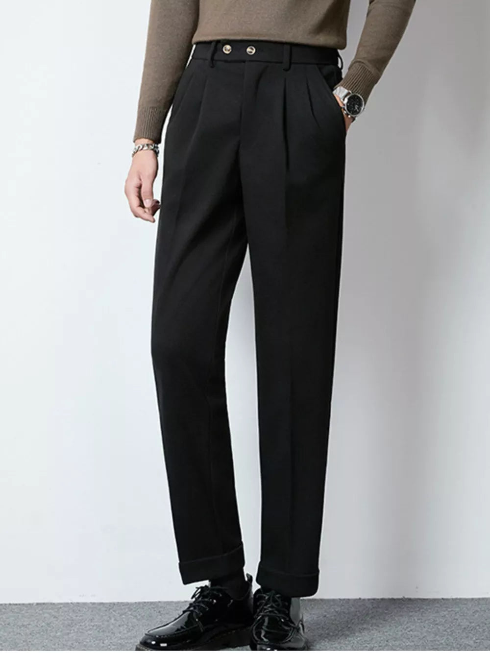 Men's black tailored pleated dress pants with cuffed hems.