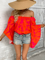 Orange geometric print off-shoulder blouse with flared bell sleeves.