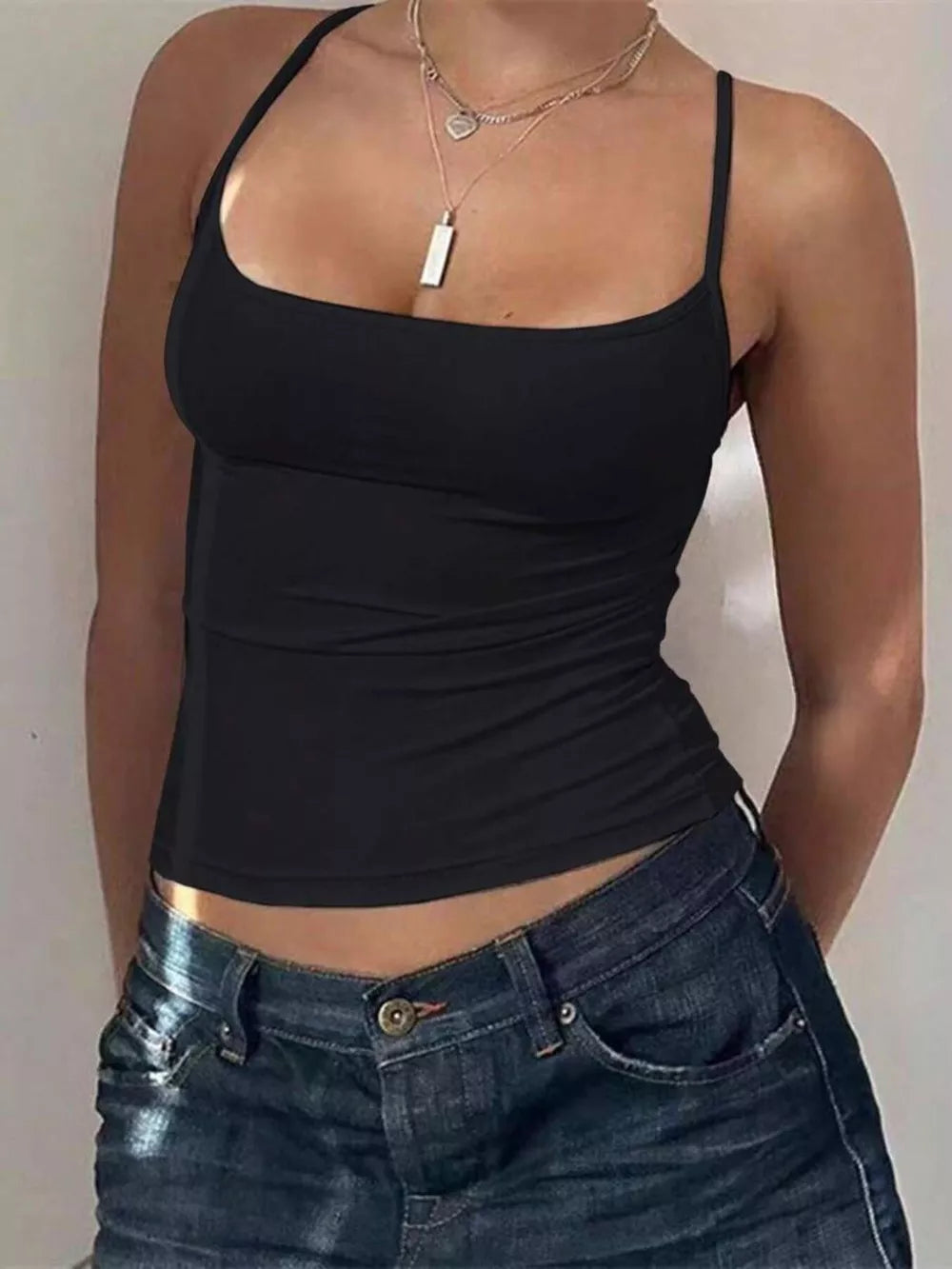 Black cami top with scoop neck and spaghetti straps, cropped length.