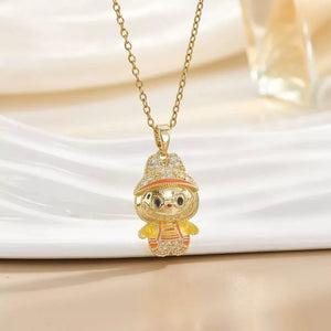 Gold-plated character pendant necklace with cubic zirconia details and orange accents.