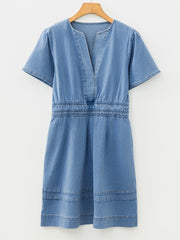 Chic denim dress with V-neck, short sleeves, elastic waist, and tiered hem.