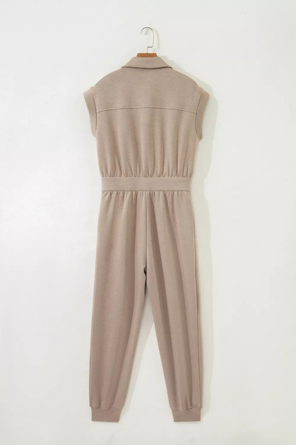Chic collared zip front romper in tan with cap sleeves and ankle cuffs.