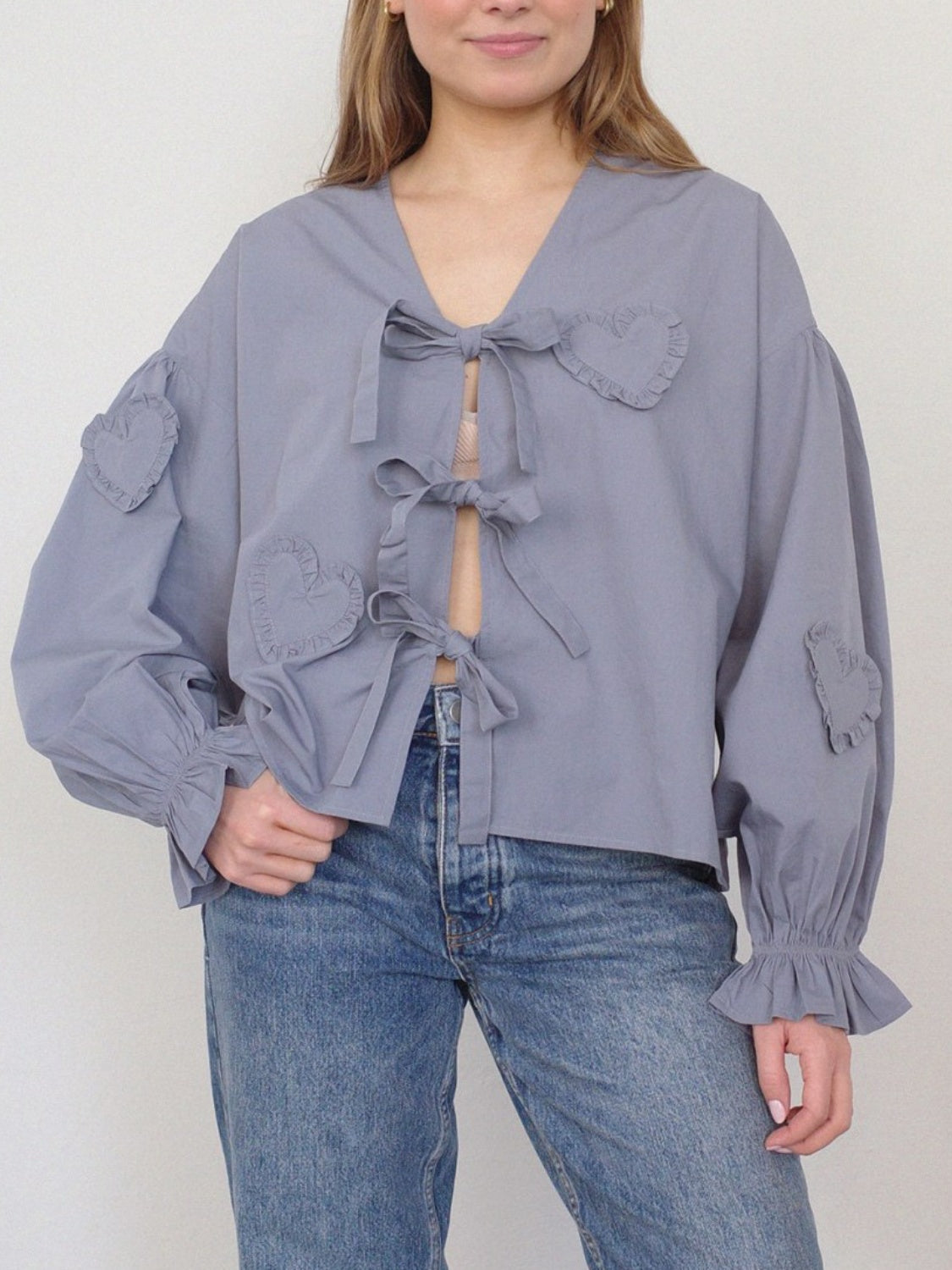 Lavender blouse with heart appliques and tie front, featuring ruffled cuffs and balloon sleeves.