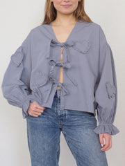 Lavender blouse with heart appliques and tie front, featuring ruffled cuffs and balloon sleeves.