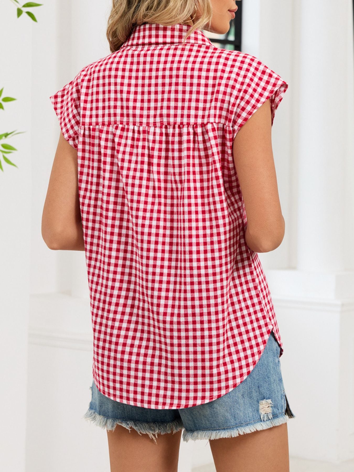 Red gingham cotton shirt with cap sleeves and button-down front, styled casually.