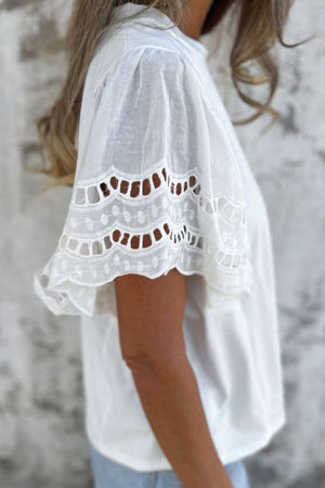 White cotton tee with eyelet lace inset flutter sleeves and scalloped hem.